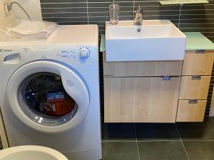 uma casa de banho com uma máquina de lavar roupa e um lavatório em Casetta Santa Fortunata Guest House em Sutri