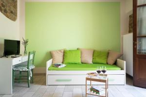 salon z zieloną kanapą i stołem w obiekcie Agriturismo La Casina nel Vigneto w mieście Larciano