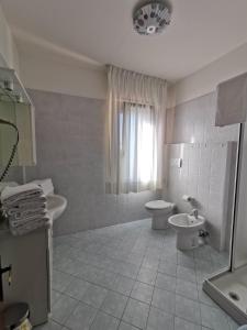 a white bathroom with a toilet and a sink at Appartamenti Vanin in Cavallino-Treporti