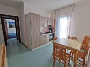 kuchnia ze stołem i krzesłami oraz jadalnia w obiekcie Appartamenti Vanin w Cavallino-Treporti