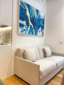 un sofá en una sala de estar con una pintura en la pared en La Ripa Camere Vernazza - Stradivari Luxury Apartment, en Vernazza