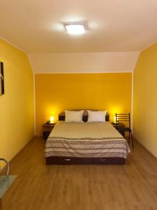 a bedroom with a bed and a yellow wall at Haus Paltinul in Sibiu