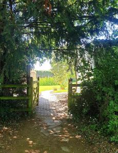 une clôture en bois et un chemin avec un portail dans l'établissement The cozy shed, à Stow-on-the-Wold