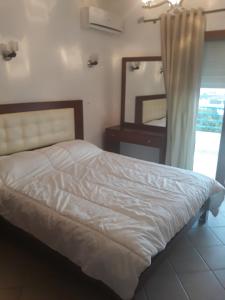 una camera da letto con un letto bianco e uno specchio di Studio Cabo Dream a Cabo Negro