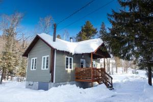 a small house with a snow covered roof in the snow at Chalets Lanaudière in Rawdon