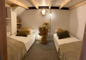 Habitación con 2 camas y una cesta en la pared en Lily l'Acrobate Aubagne-Cassis-Aix en Provence, en Aubagne