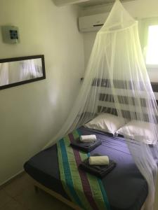 a bedroom with a bed with a mosquito net at Résidence Bleu Marine in Le Gosier