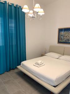 een slaapkamer met een bed met blauwe gordijnen bij Casa Nica in Mondello