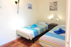 Dos camas en una habitación con toallas azules. en Casa da fonte, en Salir de Porto