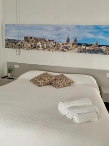 a bed with two towels and a bow tie on it at Il Canale Design House in Ragusa