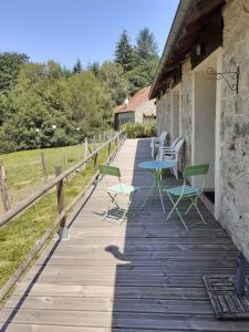 Sainte-Fortunade的住宿－MOULIN DE LACHAUD，木制甲板上摆放着椅子和桌子