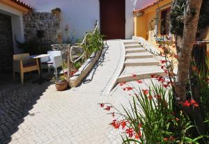 a patio with stairs and a table and flowers at Casa da fonte in Salir de Porto