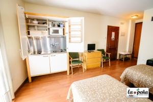 a small room with a kitchen and a bedroom at Apartamentos Turísticos La Peña in Baños de Montemayor