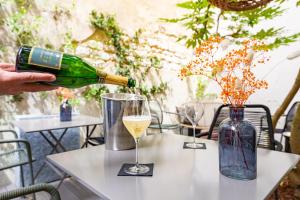a person pouring a glass of wine on a table at Hôtel Azur in Reims