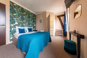 a bedroom with a blue bed and a wall mural at Hôtel Azur in Reims