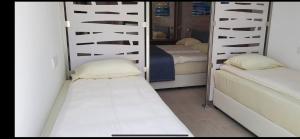 a bedroom with two bunk beds and a mirror at Karousos Beach Rooms in Ayia Napa