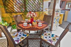 a wooden table with chairs and a vase of flowers at Casa da fonte in Salir de Porto