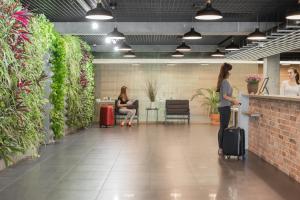 Dos mujeres están de pie en un vestíbulo del aeropuerto con equipaje en Green Loft Gdynia en Gdynia