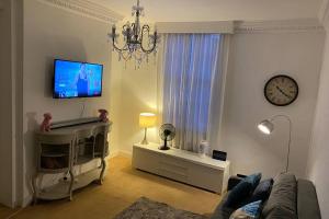 uma sala de estar com um sofá e um relógio na parede em The Regency Apartments em Brighton & Hove