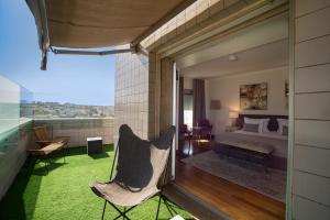 een slaapkamer met een bed en een stoel op een balkon bij Oriente 25 Housing by APT IIN in Lissabon