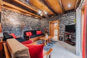 sala de estar con pared de piedra en Casa do Faial, en Santana