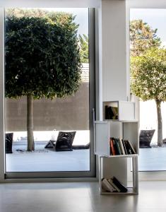 a book shelf in front of a sliding glass door at White Hotel in Vieste