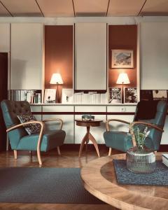 Stern B&B & Suite Apartments في نوفا ليفانتي: غرفة معيشة مع كرسيين وطاولة