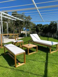 a group of benches and tables on the grass at Miramare Blue Stay in Torre Santa Sabina