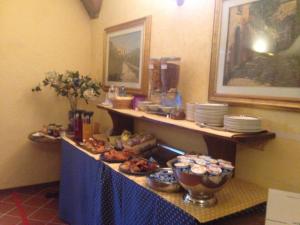 オルヴィエートにあるホテル フィリッペスキのテーブルの上に皿と食べ物を並べたビュッフェ