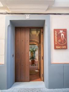 uma porta de entrada para um edifício com uma porta de madeira em Casas de Sevilla - Apartamentos Vidrio 7 em Sevilha