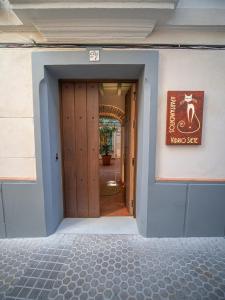 Una puerta a un edificio con un cartel. en Casas de Sevilla - Apartamentos Vidrio 7 en Sevilla