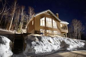 a house in the snow at night at Chalets Lanaudière in Rawdon