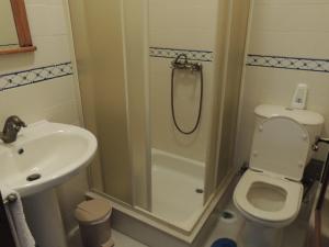 ein Badezimmer mit Dusche, Toilette und Waschbecken in der Unterkunft Casa da Praia das Paredes-Nazaré in Senhora da Vitória