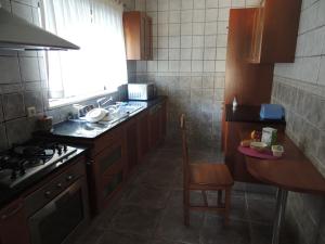 eine Küche mit einer Spüle, einem Herd und einem Tisch in der Unterkunft Casa da Praia das Paredes-Nazaré in Senhora da Vitória + 15 Fotos