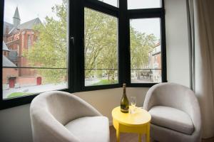 2 Stühle und ein Tisch vor einem Fenster in der Unterkunft Villa Fluisterbos in Ostende