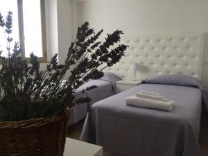 a bedroom with two beds with towels on a table at Itaka in LʼAquila