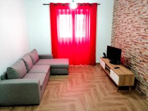 - un salon avec un canapé et un rideau rouge dans l'établissement Casa Pôr do Sol, à Ginetes