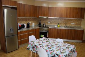 a kitchen with a table and chairs and a refrigerator at Casa Pôr do Sol in Ginetes