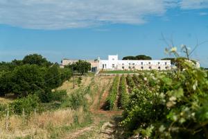 a field with a building in the background at Le Masserie Zucaro in Castel del Monte