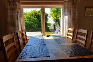 a dining room table with a view of a window at Sjöstugan, Öland - fantastiskt läge nära havet! in Löttorp