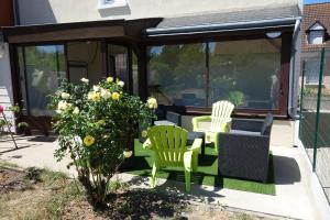 um pátio com 2 cadeiras e uma mesa em Home Bigarreaux em Le Mans