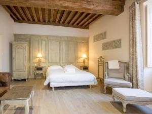 a bedroom with a white bed and a chair at Le Cara Sehiah 1D in Beaune