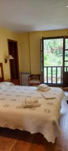 um quarto com uma cama grande e toalhas em CASA MUNIELLOS em Cangas del Narcea