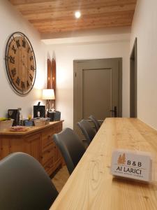 a conference room with a table and a clock on the wall at B&B Ai Larici in Bocenago