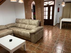 una sala de estar con un sofá y una mesa en Vivienda Rural Los Tajos de Setenil, en Setenil