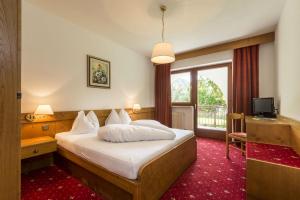 Hotel Panorama في Fleres: غرفه فندقيه بسرير ونافذه