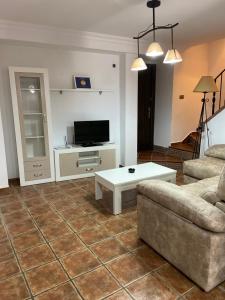 Una sala de estar con un sofá y una mesa de café. en Vivienda Rural Los Tajos de Setenil, en Setenil