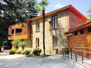 ein Steinhaus mit einer Palme davor in der Unterkunft Wald Hotel Lagodekhi in Lagodechi