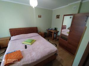 a small bedroom with a bed and a mirror at Sadyba Margaryta in Truskavets