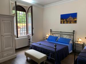 羅馬的住宿－瑪提薩別墅，一间卧室配有一张带蓝色枕头的床和一扇窗户。